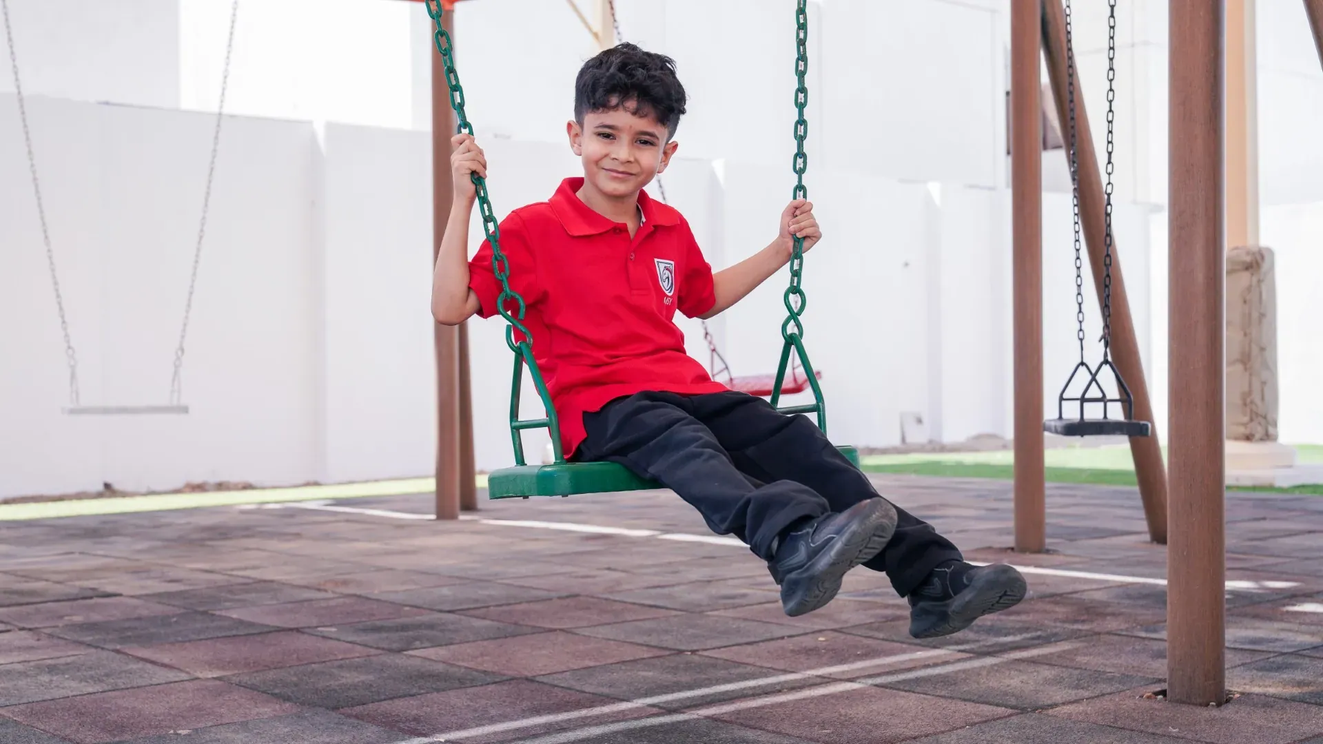 A young AISY scholar enjoying the playground swings