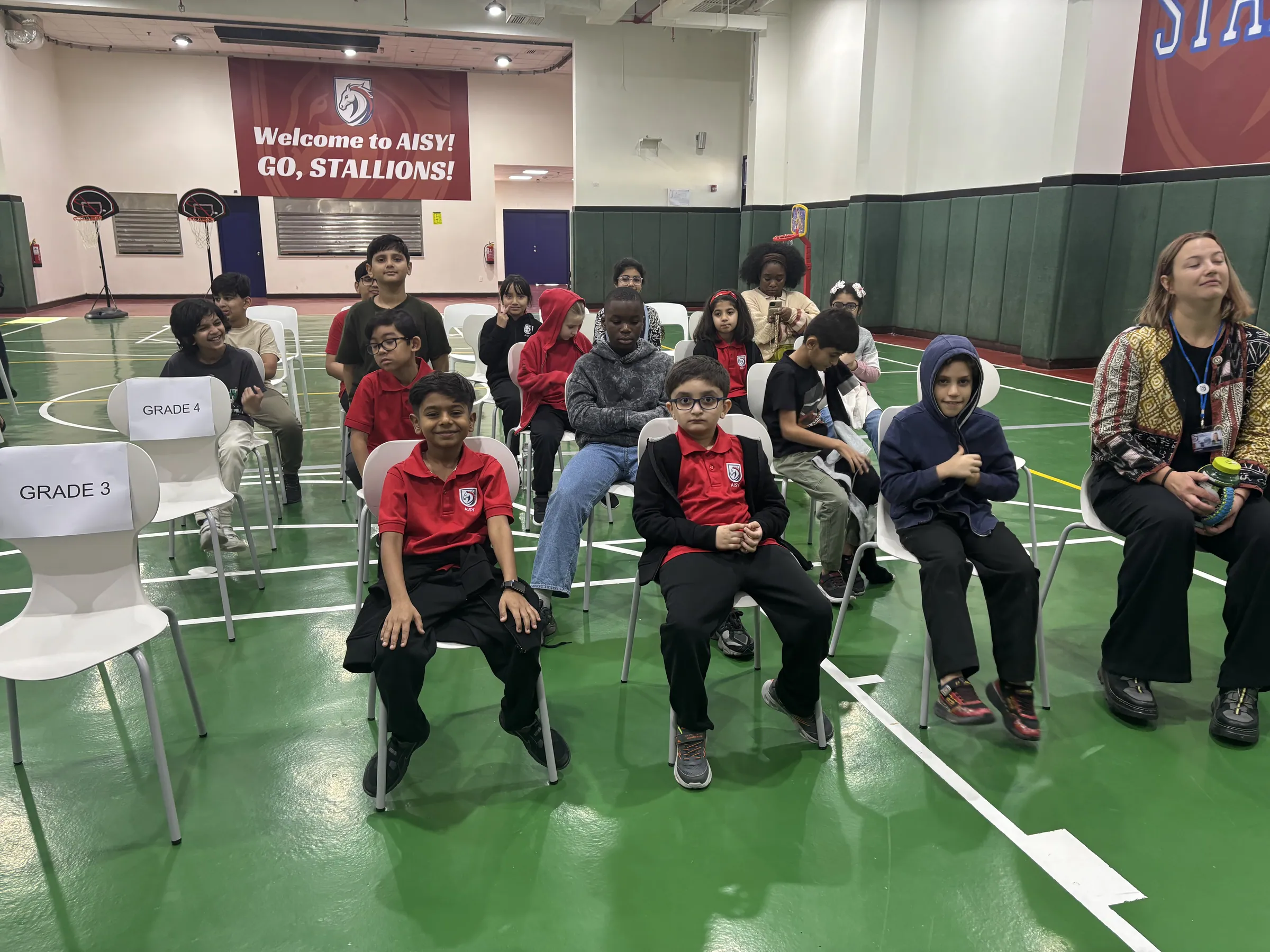 AISY scholars gathered together by grade for a school assembly