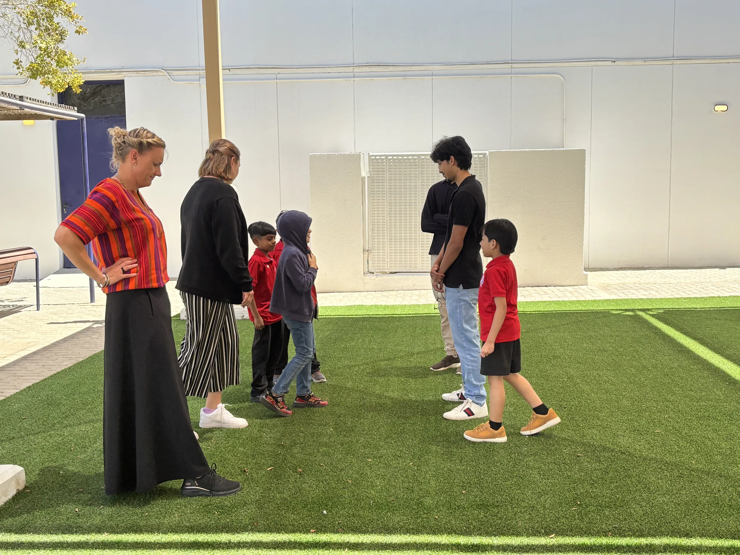 Scholars and teachers on the campus outdoor turf area