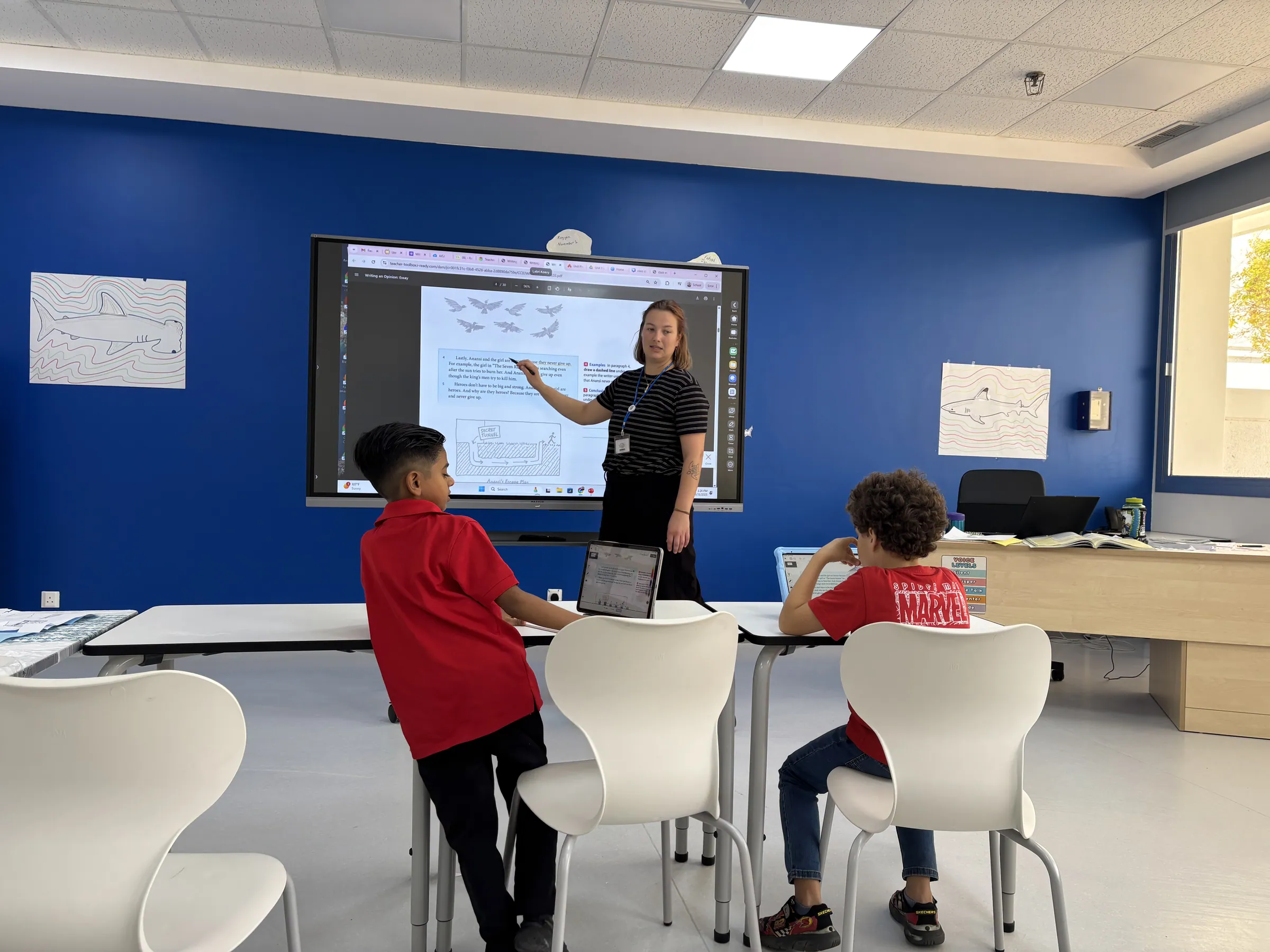 An AISY Middle School teacher leading a science lesson at the interactive whiteboard